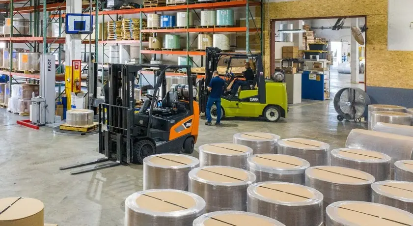 Steel strip coils in warehouse with forklifts