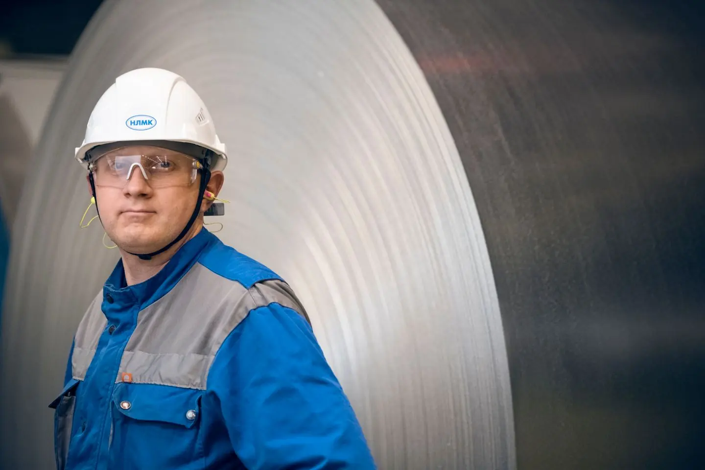 Industrial worker among steel coils